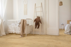 Round white carpet on the wooden floor of stylish scandinavian nursery, real photo