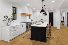 Beautiful white kitchen with dark accents in new modern farmhouse style luxury home